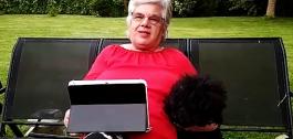 Fotograma do vídeo, cunha muller maior usando unha tablet no seu xardín.