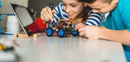 Unha rapaza e un rapaz construíndo un robot. Unha rapaza e un rapaz construíndo un robot.