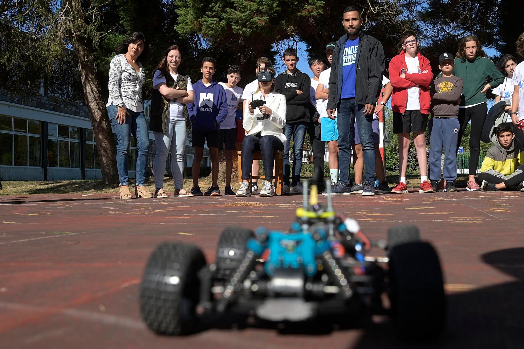 Rapaces no albergue onde unha rapaza manexa un coche teledirixido mediante FPV.