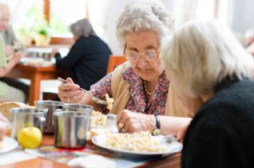 Dos mujeres mayores comiendo.