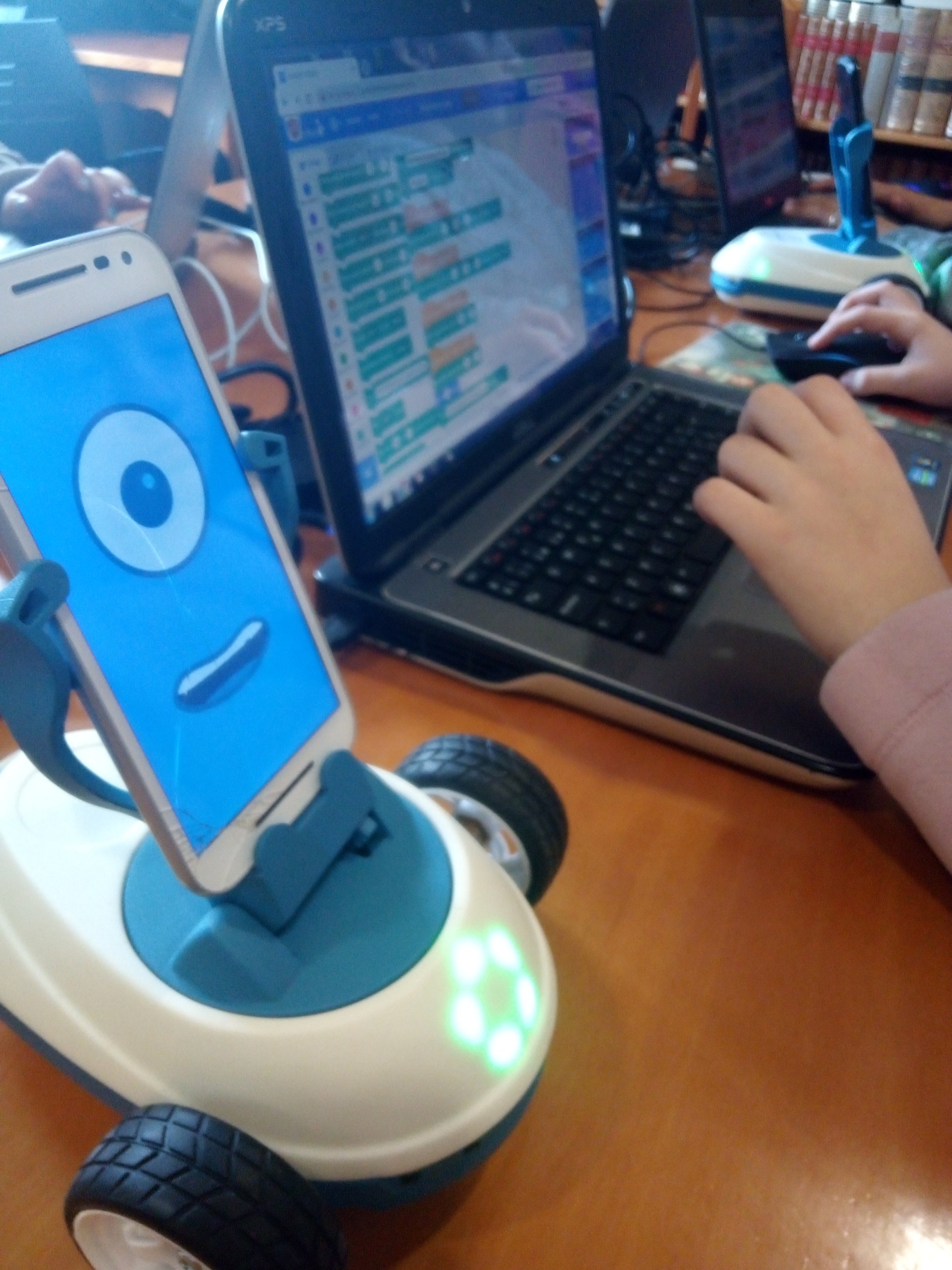 Nena programando un robot Robobo nun portátil.