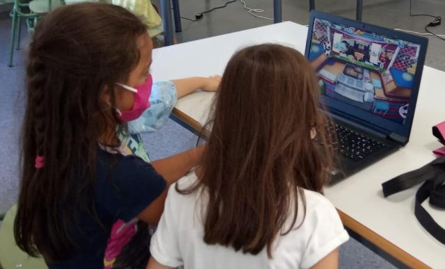 Dos niñas usando un portátil.