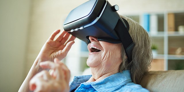 Mujer anciana usando un casco de realidad virtual.