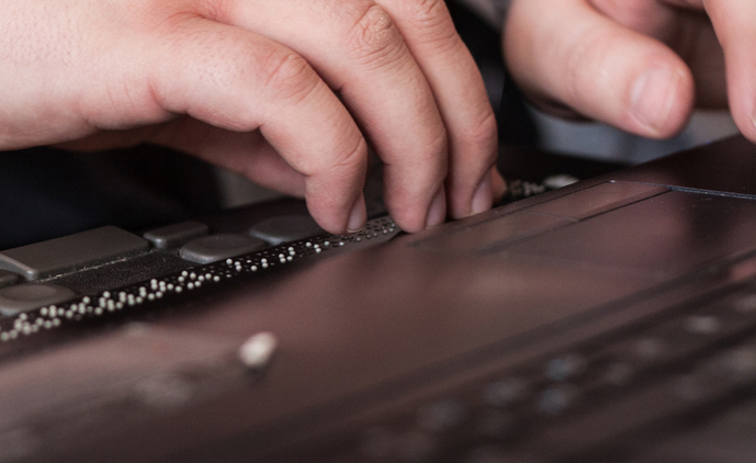 Unha persoa utiliza unha liña braille.