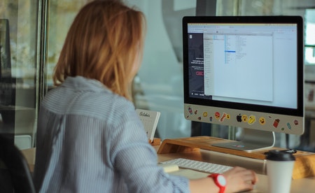 Muller de costas usando un computador.