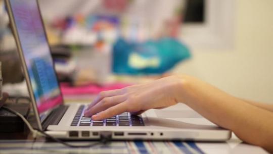 Manos sobre el teclado de un portátil.