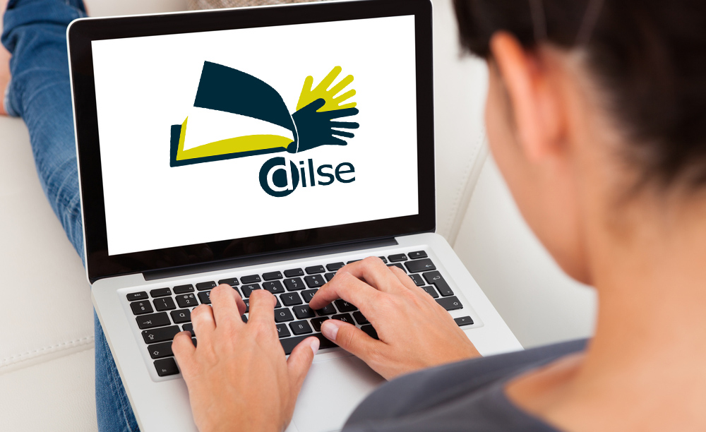 Unha muller utiliza un ordanador portátil en cuxa pantalla aparece o logo do dicionario da Lingua de Signos Española.