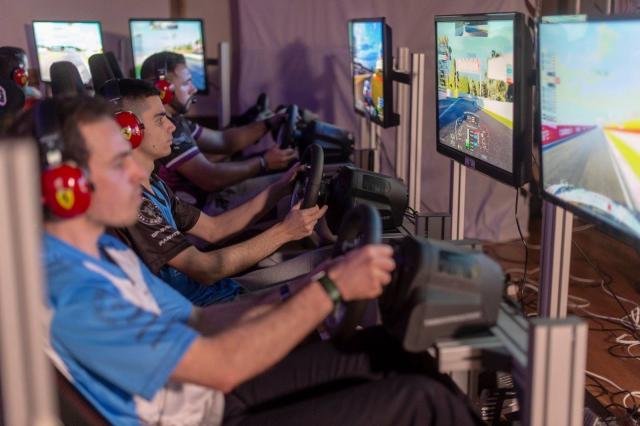 Chicos jugando en unos simuladores de conducción.