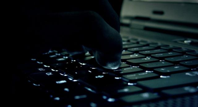 Manos de un hombre sobre el teclado de un portátil.