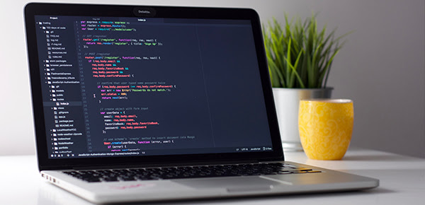 Portátil mostrando código fuente arriba de una mesa.