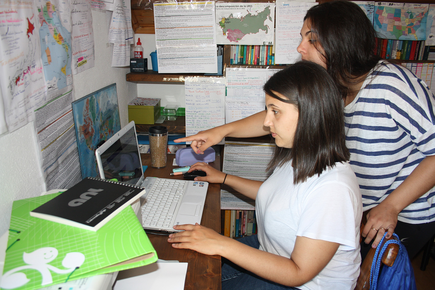 Dos jóvenes trabajando delante de un portátil.