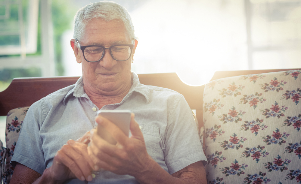 Unha persoa maior utiliza un teléfono móbil.