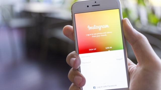 Mano sosteniendo un smartphone con la app Instagram en pantalla.