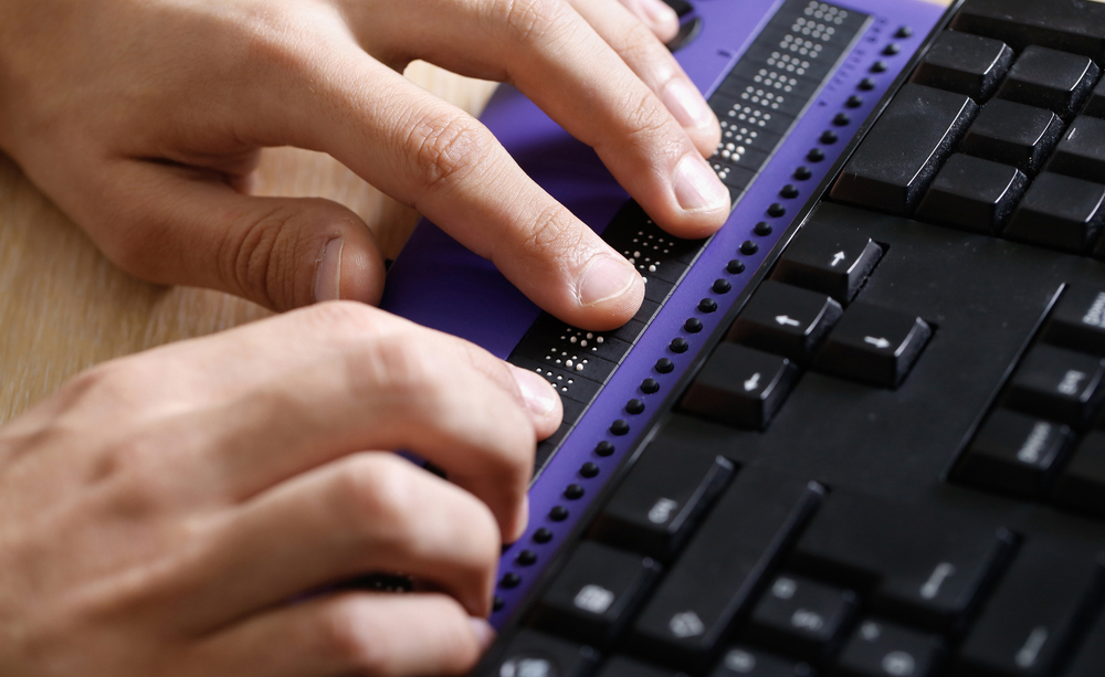 Una persona utiliza una línea braille.