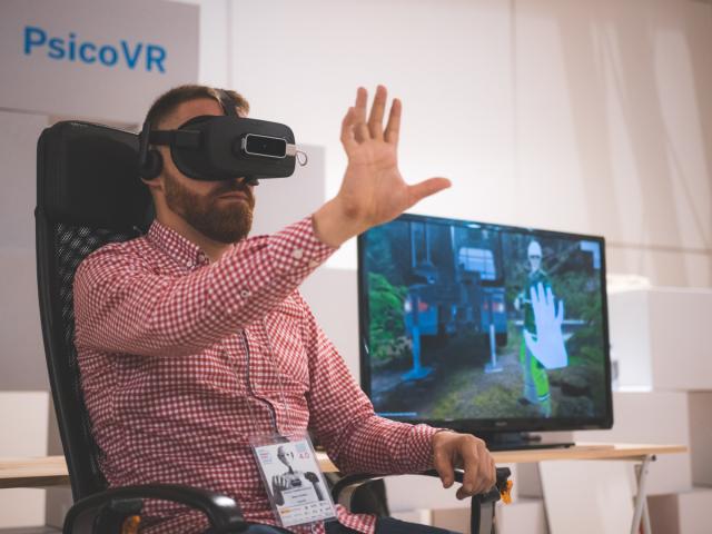 Hombre sentado usando gafas de realidad virtual.