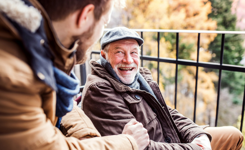 Un home maior conversa cun mozo de forma divertida.