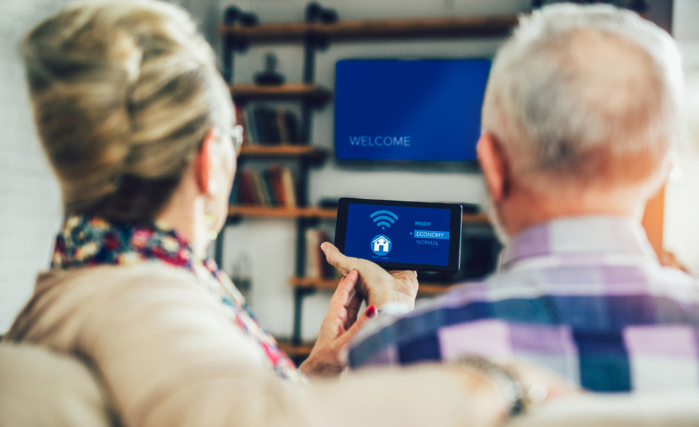 Unha parella de persoas maiores utiliza dispositivos de fogares intelixentes.