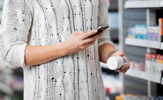 Unha persoa captura o código de barras dun medicamento co seu teléfono móbil.