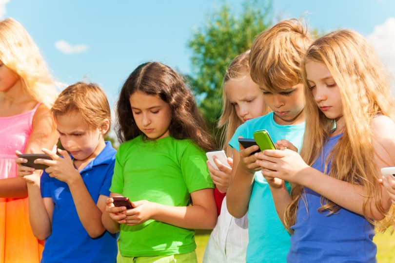 Niños usando smartphones.