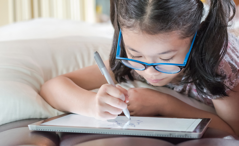 Una niña utiliza una tableta de Microsoft.