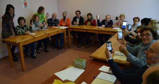 Alumnos mayores del curso enseñando los smartphones.