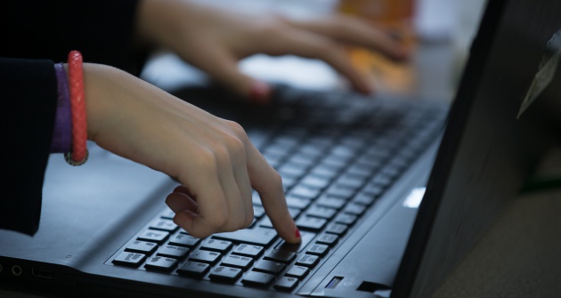 Manos de una mujer sobre el teclado de un portátil.