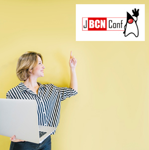 Mujer sosteniendo un portátil con la mano derecha y señalando un cartel con la mano izquierda.