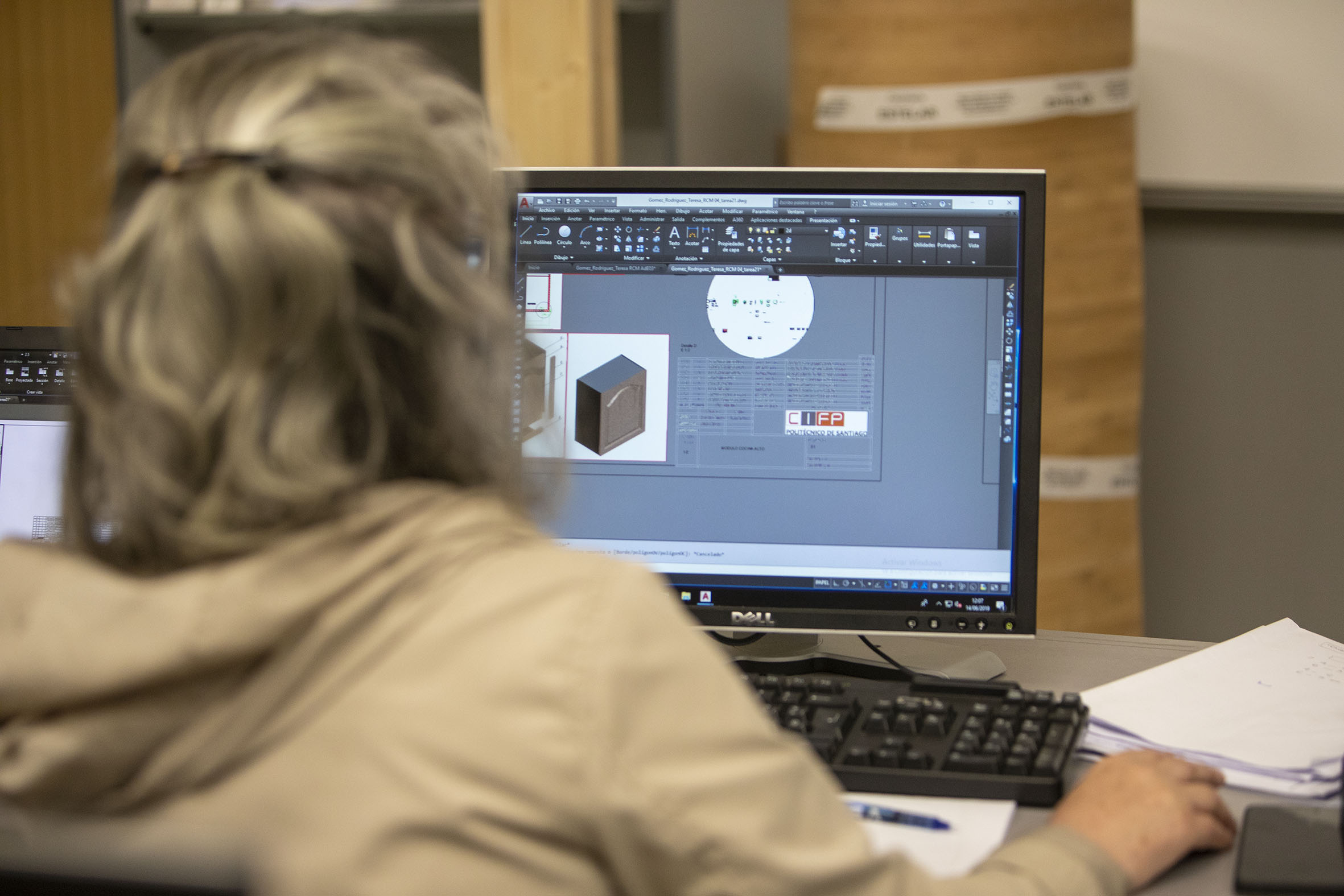 Muller de costas usando un programa de deseño nun ordenador.