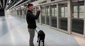 Persona ciega usando Navilens en el metro.