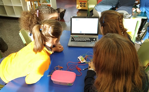 Cuatro chicas mirando un portátil.