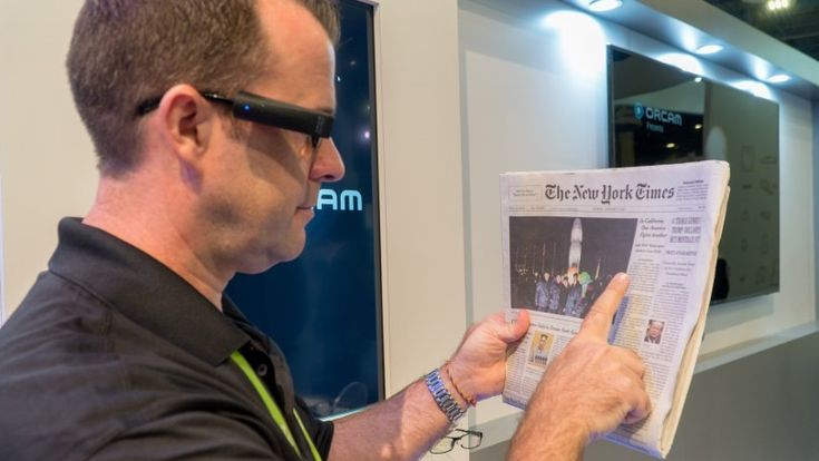 Usuario de OrCam MyEye 2.0 leyendo el periódico.