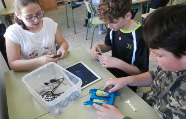 Niños ensamblando un robot.