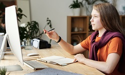 Moza diante dun ordenador. Foto de Julia M Cameron en Pexels.