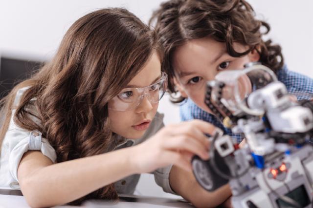 Dos niñas jugando con un robot.