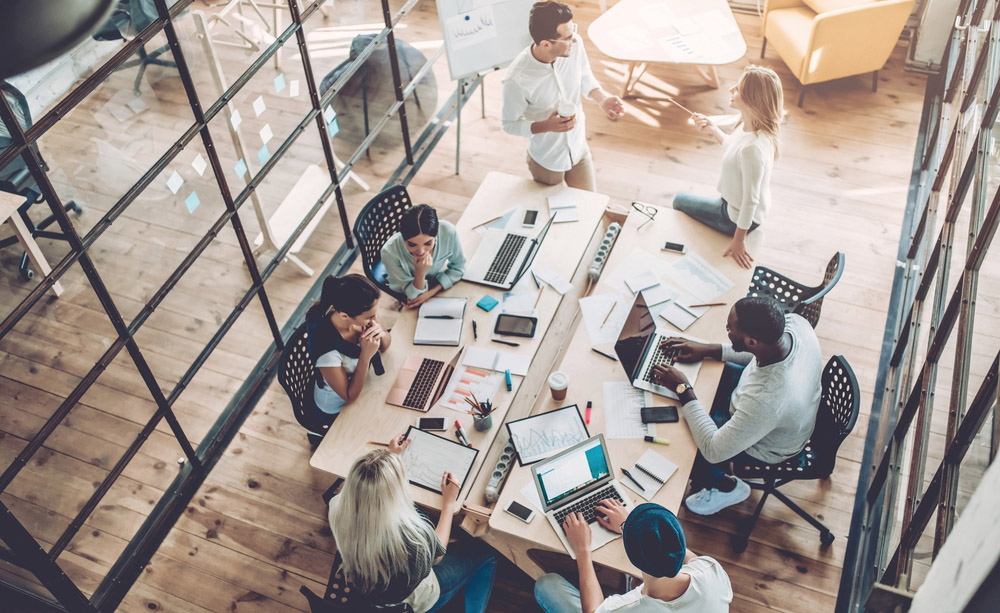 Varias persoas traballando ao redor dunha mesa nunha startup.