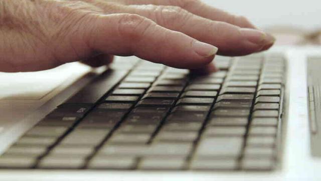 Mano de persona mayor sobre un teclado.