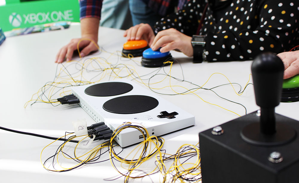 Varias persoas utilizan o mando adaptado de Xbox mediante pulsadores.