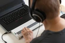 Usuario cego usando unha liña de Braille.