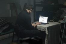 Hombre usando un portátil en el garaje de una vivienda.