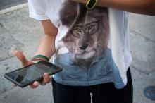 Persoa nova sostendo un smartphone na man.