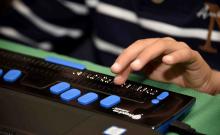 Una persona utiliza una línea braille conectada a un ordenador.