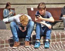 Dous mozos usando smartphones.