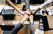 Choque de cinco puños enzima de una mesa con dispositivos electrónicos.