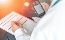 Un doctor utiliza su teléfono móvil para el seguimiento de un paciente.