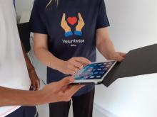 Dous voluntarios usando unha tableta.