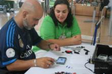 Unha persoa con lesión medular coa súa coidadora usando un smartphone.