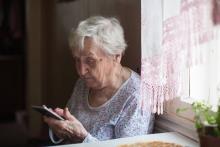 Muller maior usando un smartphone.