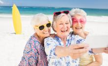 Tres mujeres mayores se hacen un 'selfie' en una playa.