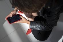 Vista cenital dunha muller usando un smartphone.