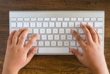 Mans dun neno sobre un teclado.